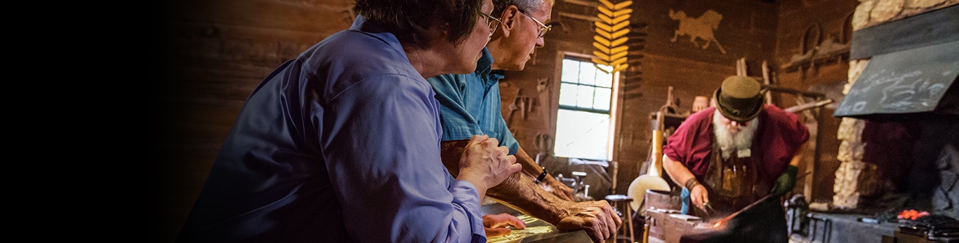 Et ældre par ser på smedjen, et stykke af en metalhammer ved Historic Site i Grand Detour, Illinois, USA