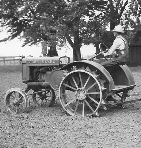 Historisk John Deere "GP"-traktor til generelle formål, der trækker en John Deere nr. 7 motorharve på marken