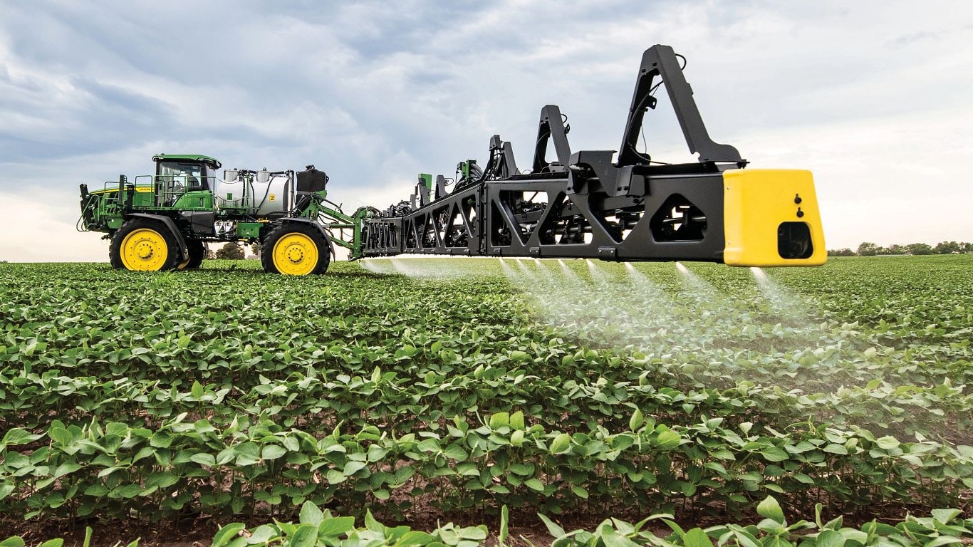 Nærbillede af en John Deere sprøjtebom på en åben mark.