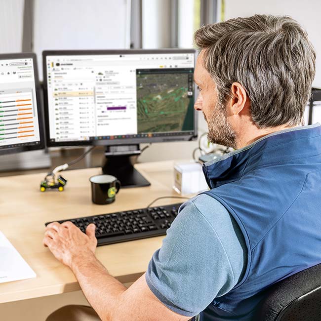 En chefgreenkeeper sidder på sit kontor, og ser på de data, der er indsamlet af Smart Greenkeeping Technology.