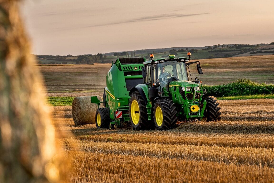 John Deere traktor ballepresning halm med en stor rundballepresser i en gylden stubmark