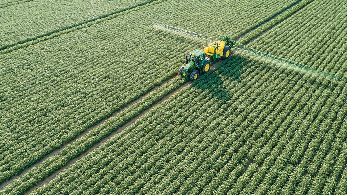 John Deere 6M Serie traktor tr&aelig;kkende M700 trailerspr&oslash;jte i kartoffelmark