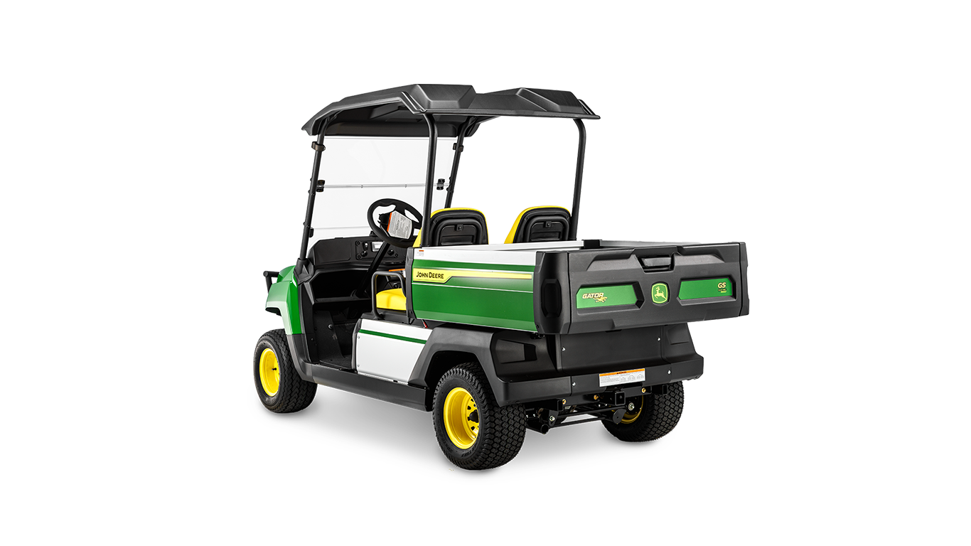 En John Deere Gator GS benzinmodel set bagfra i en vinkel, der viser lad, to sæder og beskyttelsestag.
