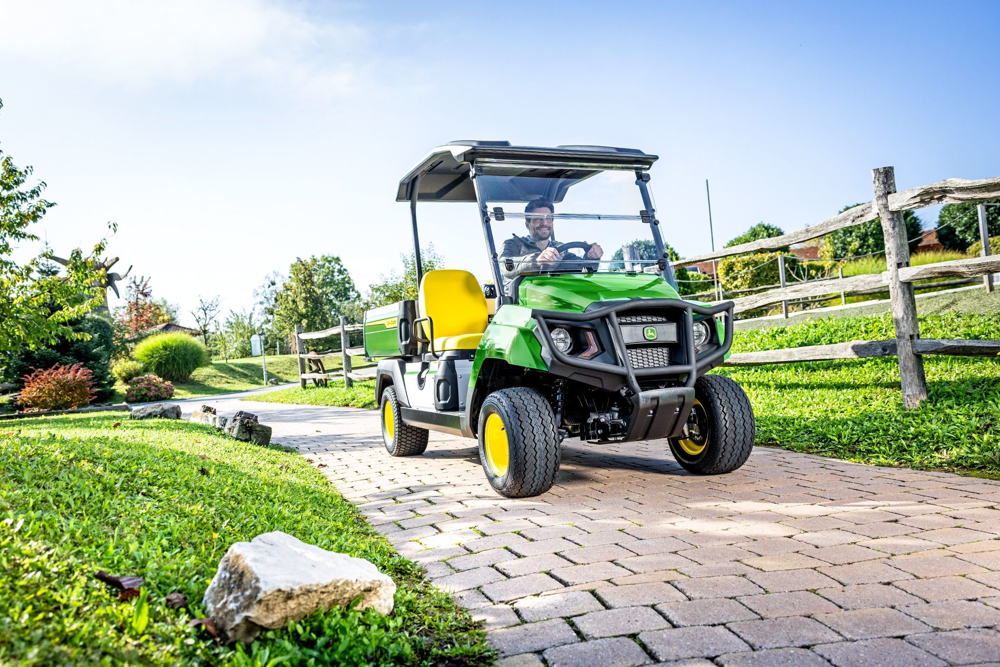 Gator GS transporter, der kører på en asfalteret sti i et anlagt område Gator GS transporter, der kører på en asfalteret sti i et anlagt område