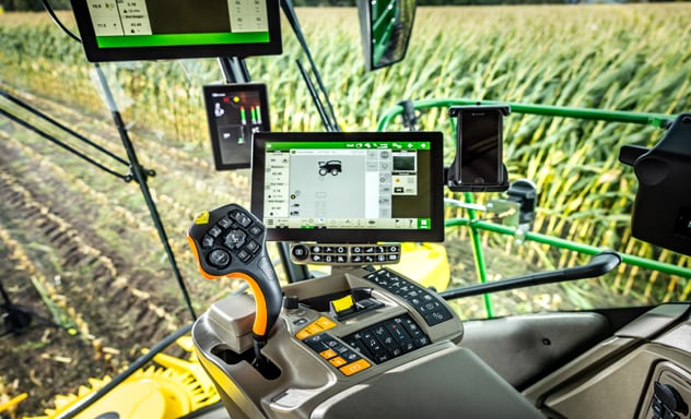 Selvkørende finsnitter F9 700, der fylder en Joskin vogn, der trækkes af en 6R John Deere traktor