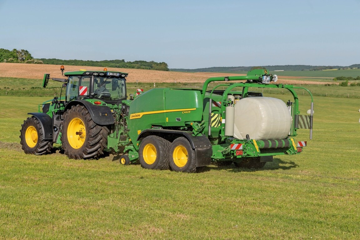 John Deere C442R-kombipresse trukket af en John Deere 6R 185, der laver ensilageballer med høj presningsgrad