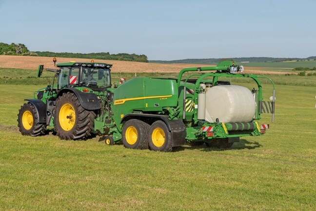 John Deere C442R-kombipresse trukket af en John Deere 6R 185, der laver ensilageballer med høj presningsgrad