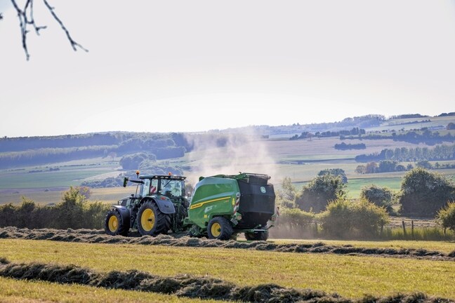 John Deere V462R trukket af en John Deere 6R 185-traktor, der presser høballer