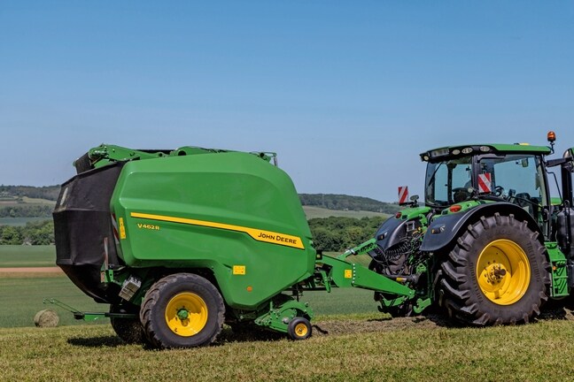 John Deere V462R trukket af en John Deere 6R 185-traktor, der presser høballer